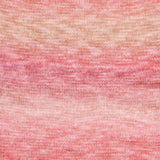 A close-up of a textured knit fabric with a marled gradient pattern transitioning from peach and beige at the top to soft pink at the bottom.
