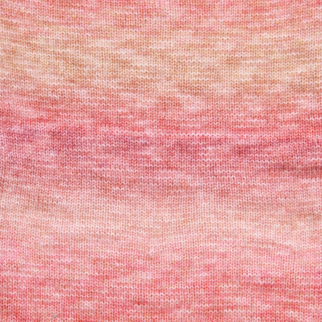A close-up of a textured knit fabric with a marled gradient pattern transitioning from peach and beige at the top to soft pink at the bottom.
