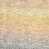 A close-up of a knitted fabric with a soft ombre gradient transitioning from pale yellow at the top through warm beige to light gray at the bottom.