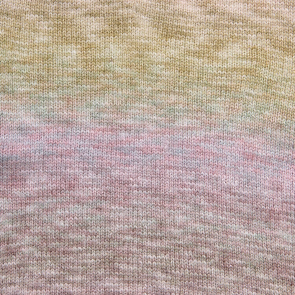 Close-up of a knitted fabric with a soft variegated color pattern transitioning from pale yellow at the top through muted green and lavender into dusty pink at the bottom.