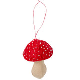 A red felt mushroom ornament with white polka dots and a beige fabric stem, hanging by a red string on a plain white background.