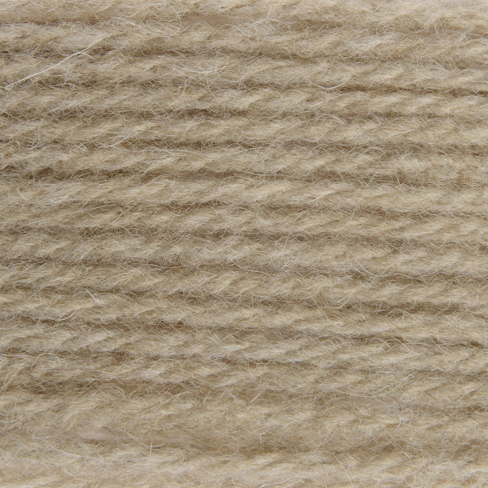 A close-up texture shot of a soft, fuzzy yarn or fleece material in a warm light beige color.