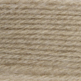 A close-up texture shot of a soft, fuzzy yarn or fleece material in a warm light beige color.