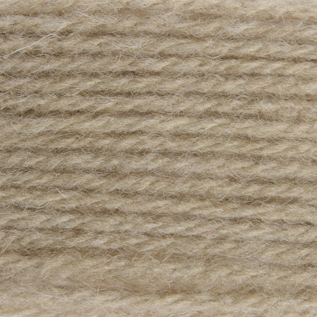 A close-up texture shot of a soft, fuzzy yarn or fleece material in a warm light beige color.