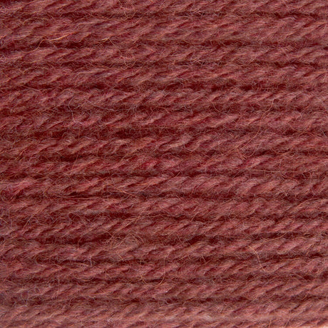 A close-up texture shot of twisted yarn in a dusty rose or mauve-brown color, filling the entire frame.