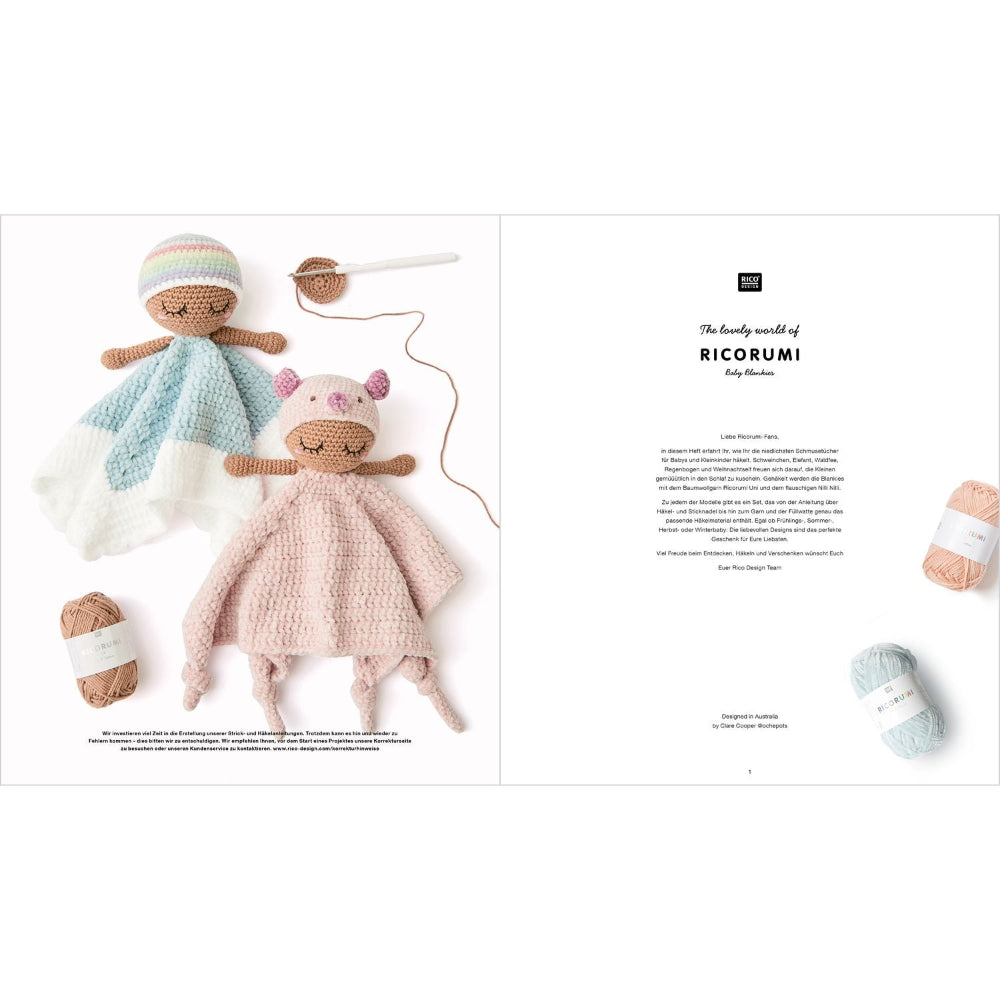 An open book or magazine spread showing a crocheted amigurumi doll with a light blue and white blanket on the left and a pink and white bear-themed blanket on the right, with yarn balls and crochet hooks arranged around them.