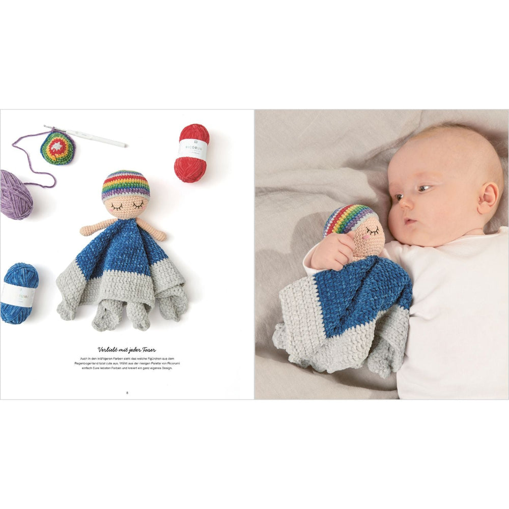Crocheted doll with rainbow hairband and baby wearing similar outfit on a white background