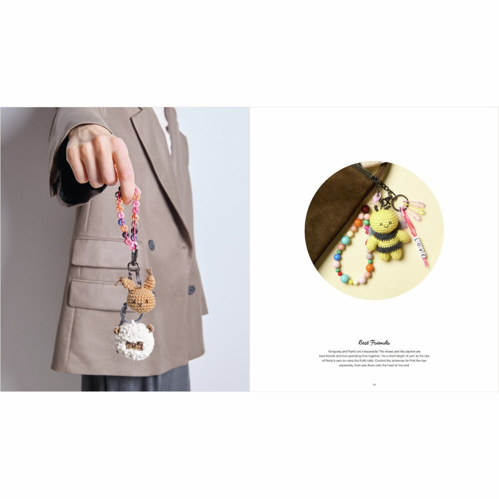 Person holding a colorful keychain with various charms against a plain background