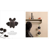 A two-page knitting pattern booklet spread showing a black crocheted bat toy on the left and a styled room scene with a black bat-shaped wall hanging on a shelf on the right.