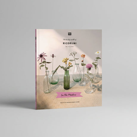 A book cover titled "The lovely world of RICORUMI" featuring several glass vases with dried and fresh flowers on a tabletop against a soft beige background. The cover includes the publisher mark "BLOOM" at the top and a pink banner reading "In The Meadow" near the bottom.