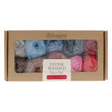 Box of Scheepjes stone washed Aura yarn with colourful skeins on a white background