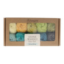 Box of Scheepjes Grounding stone washed yarn with colourful skeins on a white background