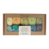 Box of Scheepjes Grounding stone washed yarn with colourful skeins on a white background