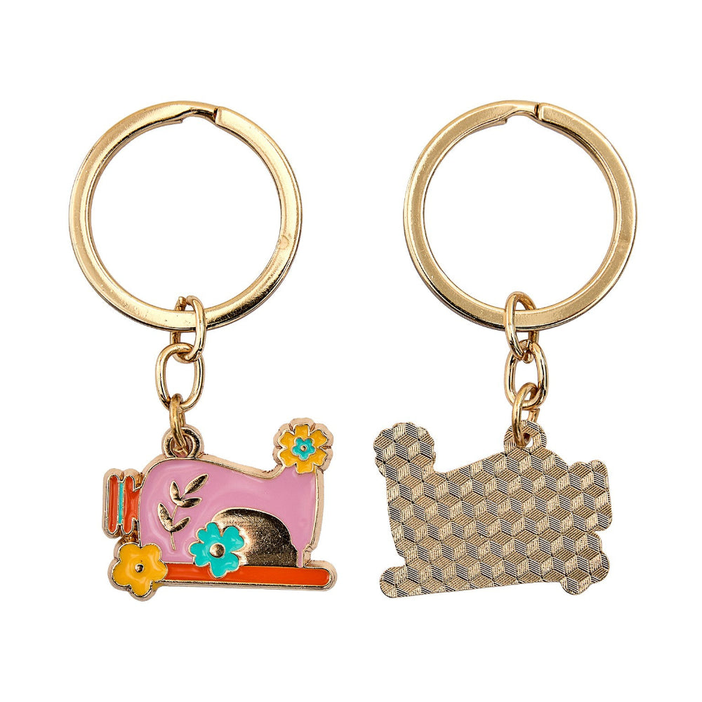 Two keychains with sewing machine designs on a white background