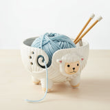 Ceramic sheep yarn holder with a white background