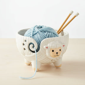 Ceramic sheep yarn holder with a white background