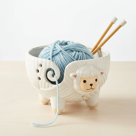 Ceramic sheep yarn holder with a white background
