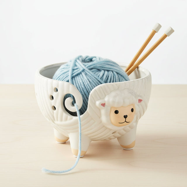 Ceramic sheep yarn holder with a white background