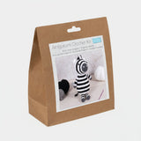 Amigurumi crochet kit packaging with a zebra toy on a white background