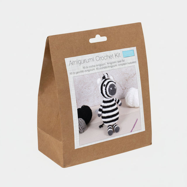 Amigurumi crochet kit packaging with a zebra toy on a white background