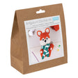 Amigurumi Crochet Kit in a brown paper bag package, featuring a printed front label with a crocheted fox illustration and small crochet yarn balls visible at the top.
