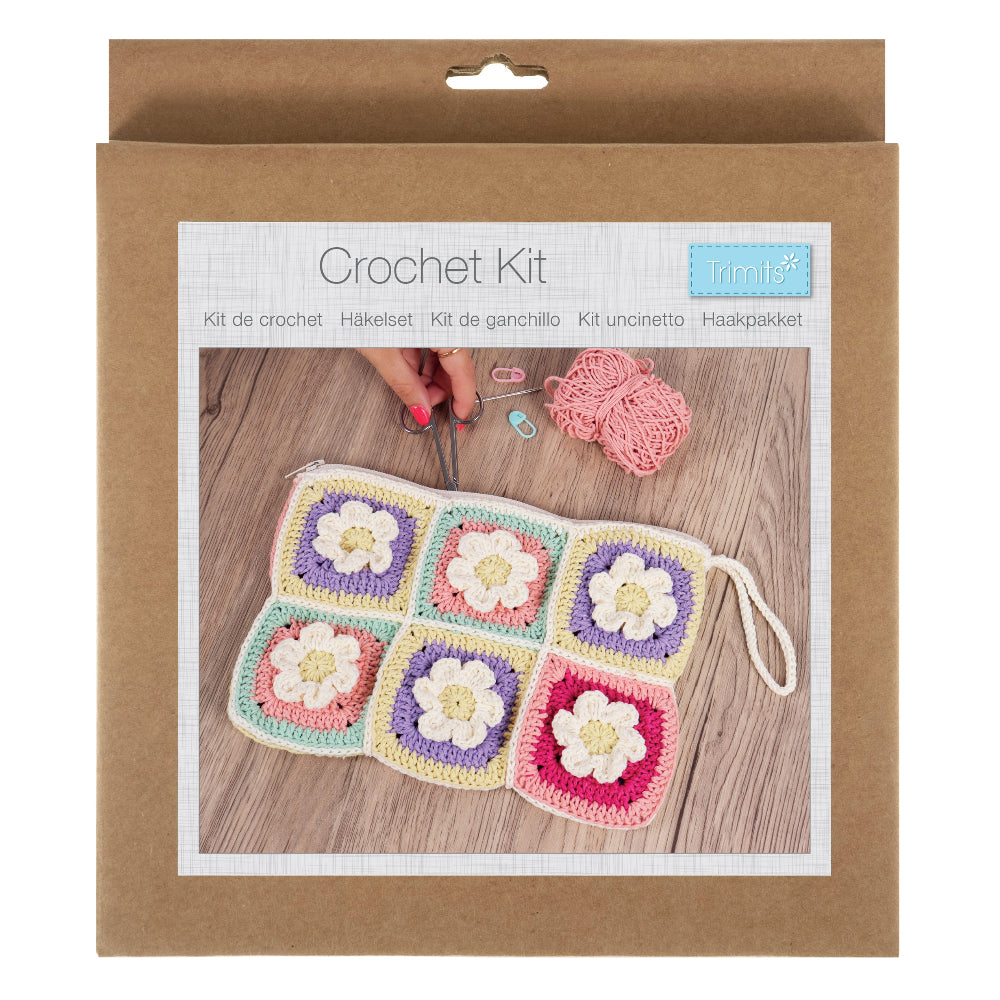 Crochet kit packaging with a sample of crocheted squares on a wooden surface.