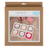 Crochet kit packaging with a sample of crocheted squares on a wooden surface.