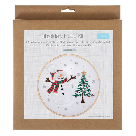 Embroidery Hoop Kit in its original brown kraft paper packaging, featuring a festive snowman and Christmas tree design on the front label.