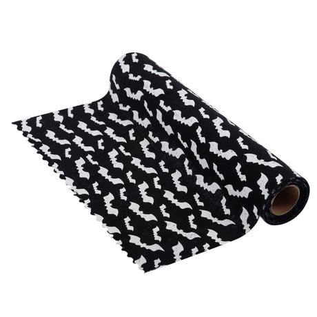 Black and white patterned fabric with a repeating bat silhouette design, shown partially rolled on a white background.