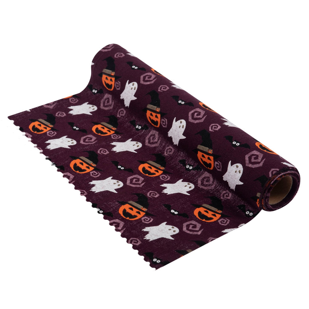 A roll of Halloween-themed fabric with a dark purple background and a repeating pattern of white ghosts, orange jack-o'-lanterns, black bats, and witch hats, shown on a plain white background.