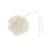 A fluffy cream faux fur pom-pom ornament with a matching cream ribbon tail, shown on a solid white background.