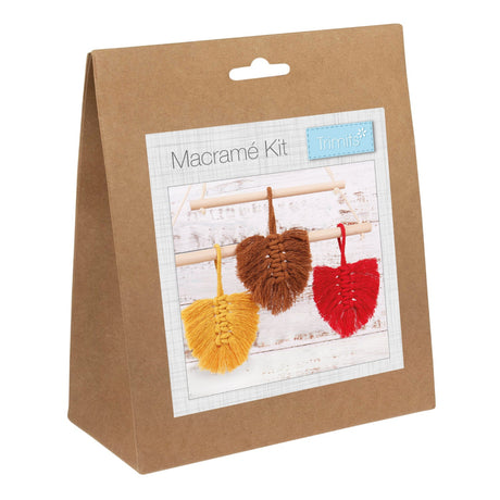 A brown kraft paper bag package labeled 'Macramé Kit' with a photo of three woven macramé leaves in yellow, brown, and red on a white background.