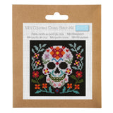 A Mini Counted Cross Stitch Kit by Trimits, featuring a sugar skull design on a black background with colourful floral details, presented in its brown cardboard packaging with a white label insert.