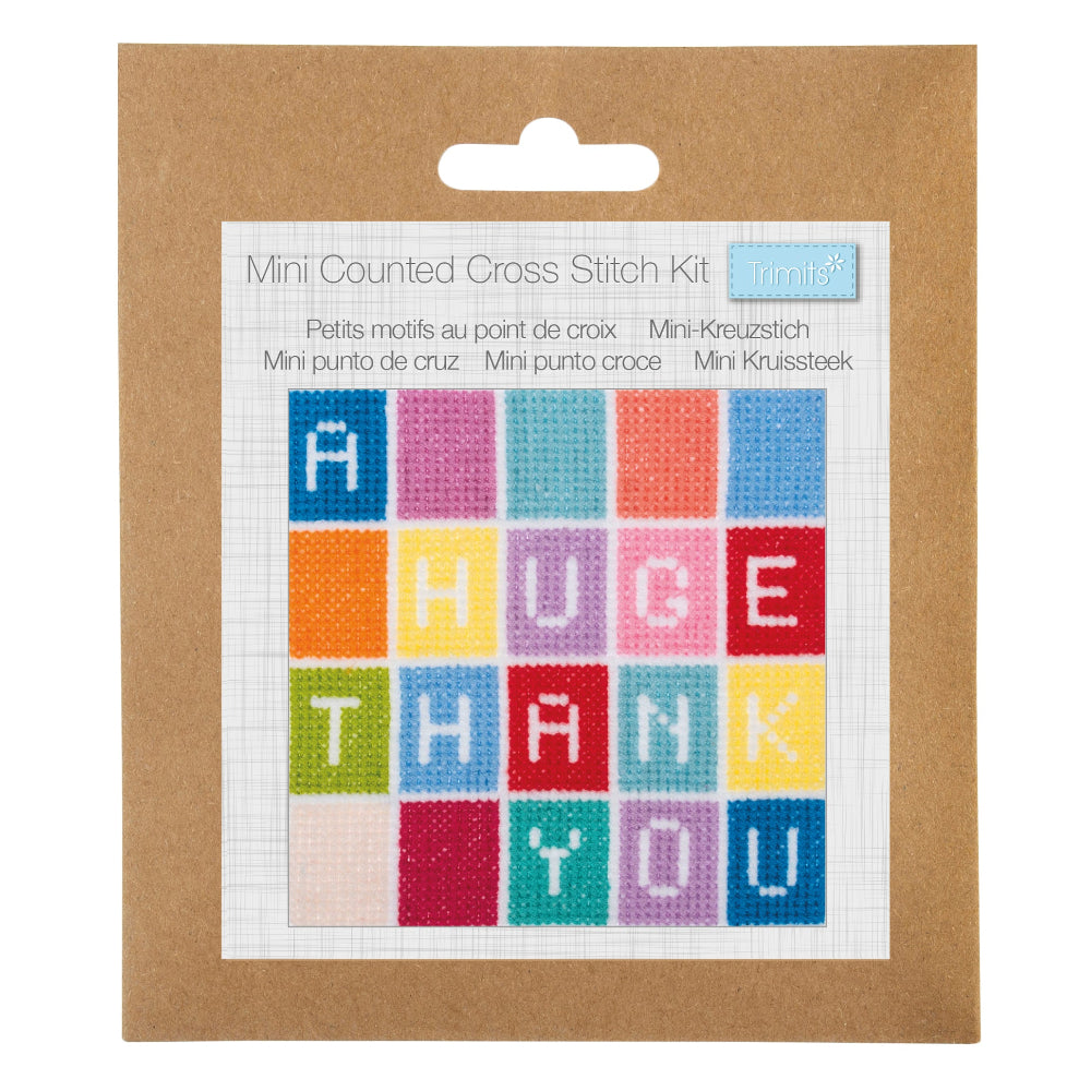 A Mini Counted Cross Stitch Kit by mini kit, featuring a colorful 'HUGE THANK YOU' cross stitch design on a white grid card, mounted on a brown kraft paper backing card with a hanging tab.