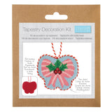 Trimits Tapestry Decoration Kit in its original brown kraft paper packaging, featuring a heart-shaped tapestry design with pink and blue sections, green holly leaves, and red stitching details.