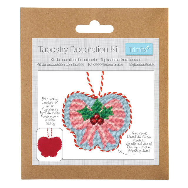 Trimits Tapestry Decoration Kit in its original brown kraft paper packaging, featuring a heart-shaped tapestry design with pink and blue sections, green holly leaves, and red stitching details.