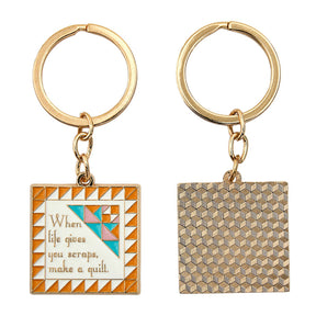 Two keychains with geometric designs and text on a white background