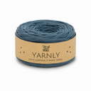 A roll of Yarnly faux leather t-shirt yarn in a muted slate blue color, wrapped in a kraft paper band with the brand name clearly visible.