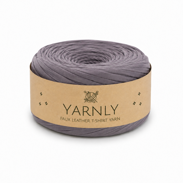 A roll of Yarnly faux leather t-shirt yarn in a muted grayish purple color, wrapped in a kraft paper band with the brand name 'YARNLY' printed on it, set against a plain white background.
