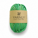 A ball of green glitter T-shirt yarn wrapped in a brown paper label that reads 'YARNLY LUSTRE T-SHIRT YARN' on a white background.
