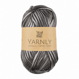 A skein of Yarnly Metallic T-Shirt Yarn in a dark gray metallic shade, wrapped with a brown kraft paper label, on a plain white background.