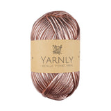Ball of metallic rose gold yarn with Yarnly label on a white background