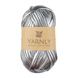 A skein of metallic silver t-shirt yarn with a brown paper label reading 'YARNLY METALLIC T-SHIRT YARN' on a plain white background.