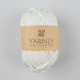 Ball of white yarn with a brown label on a white background